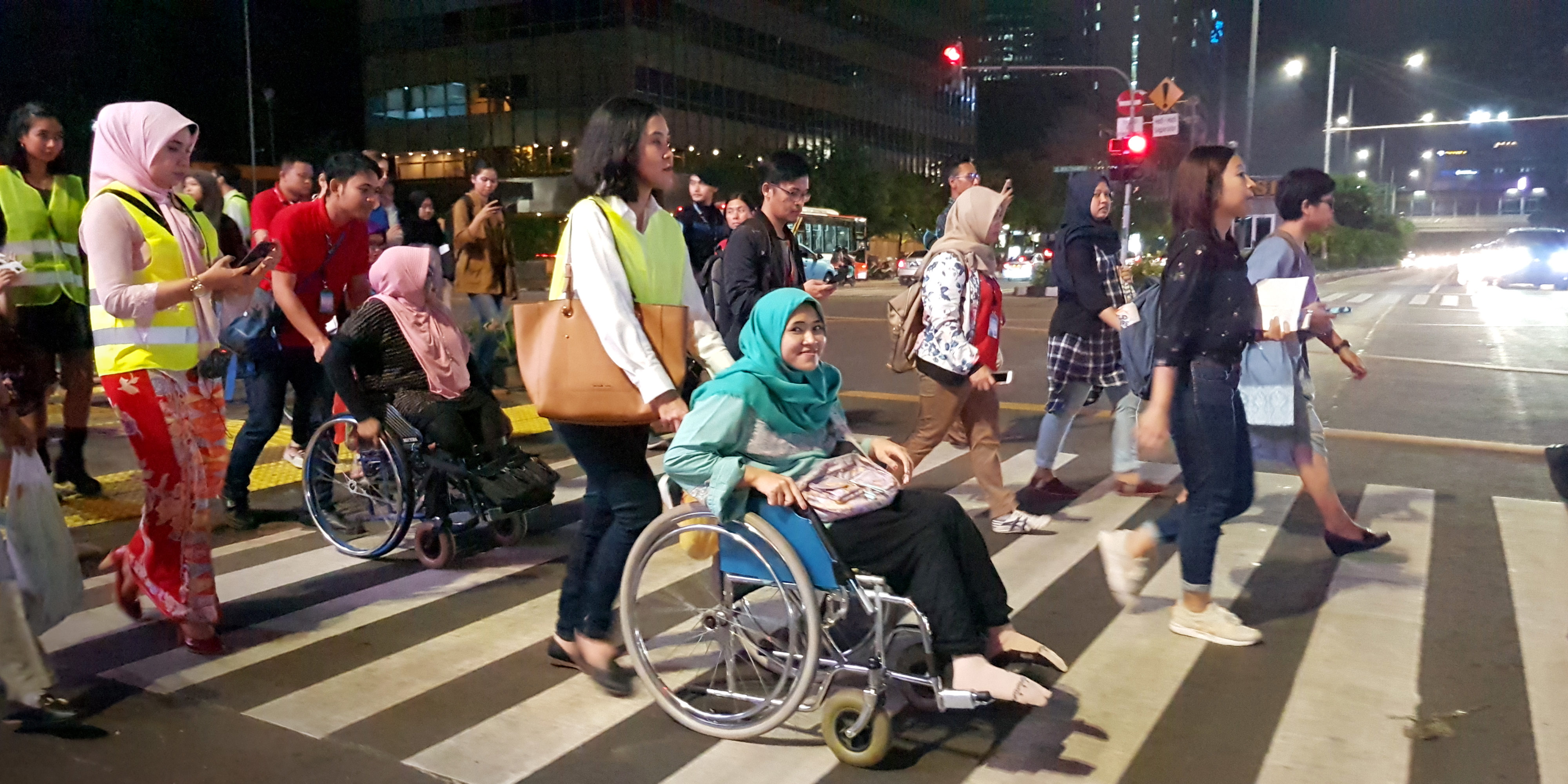 Women in wheelchairs at crosswalk