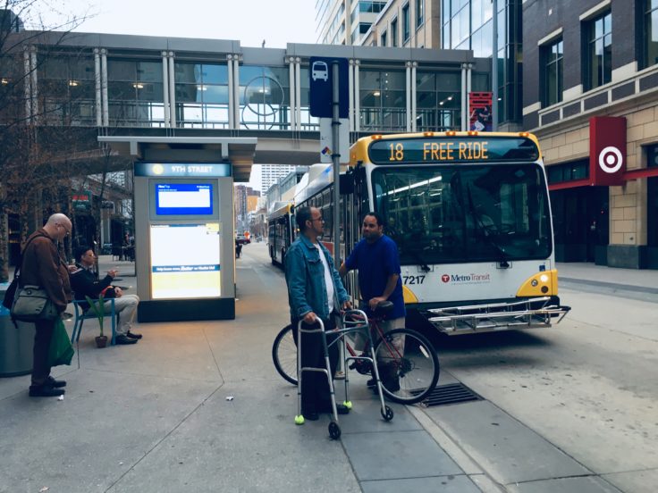 Man with bicycle in front of Minneapolis Bus