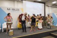 Man in red blazer dancing along with drummers at event in Brazil