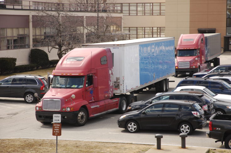 Huge truck passing parking lot