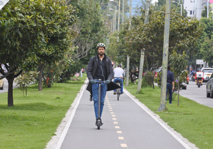 Man on E-Scooter on bike lane in Bogota