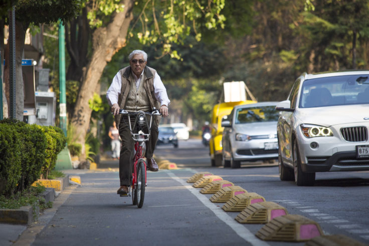 Man on bicycle in protected bike lane in Mexico City